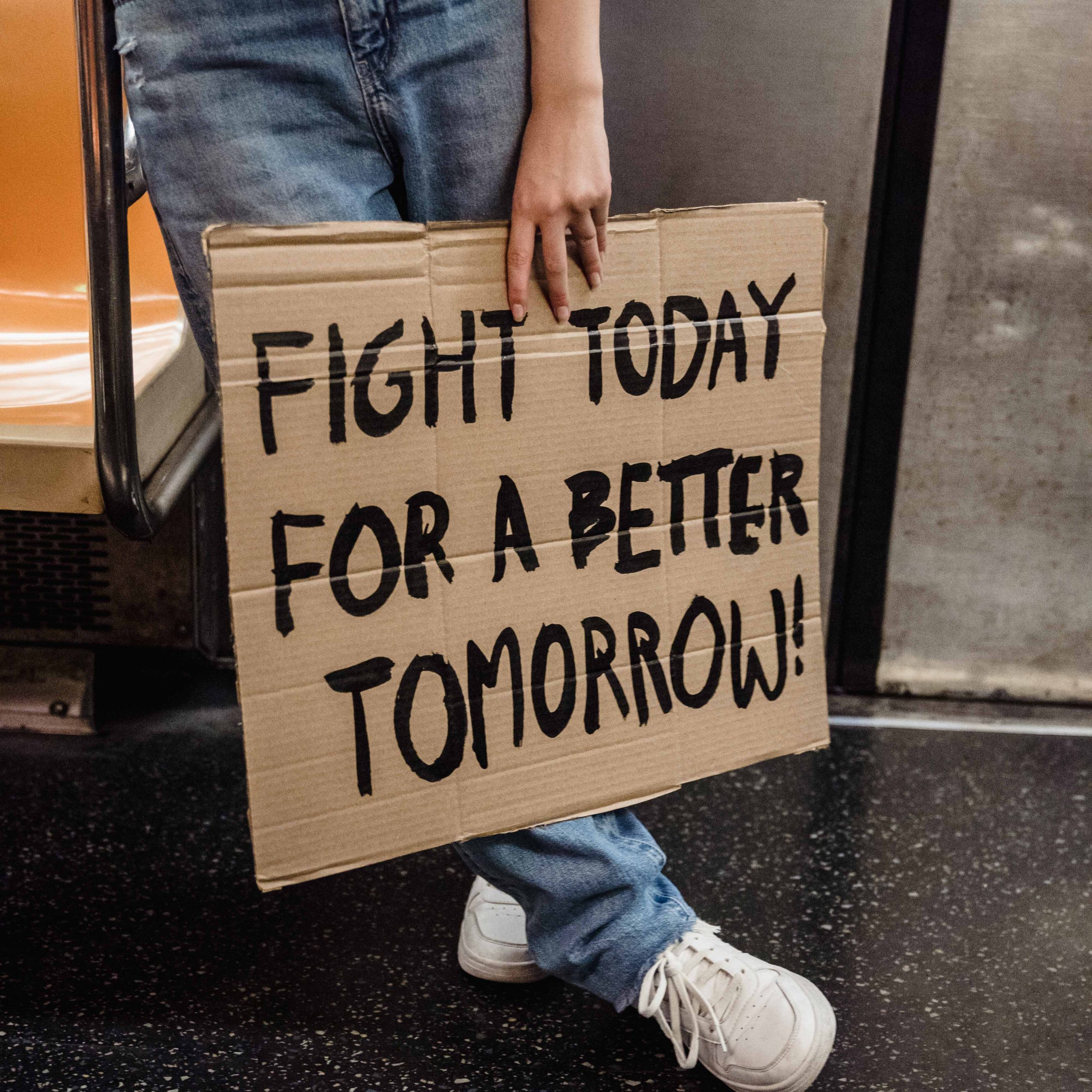 risco catastrófico global, jovem segura cartaz com frase de protesto "lute hoje para um futuro melhor"