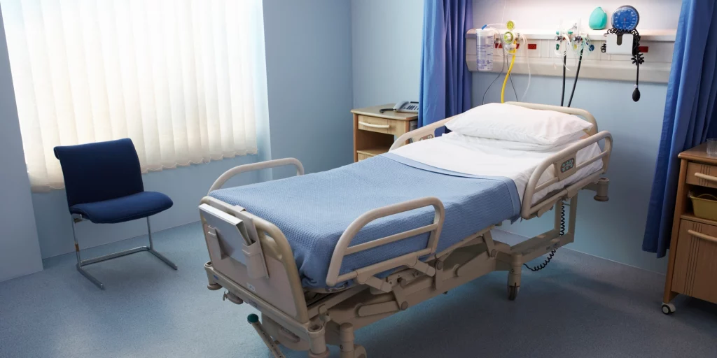 foto de uma uti de hospital, focalizando uma cama hospitalar vazia